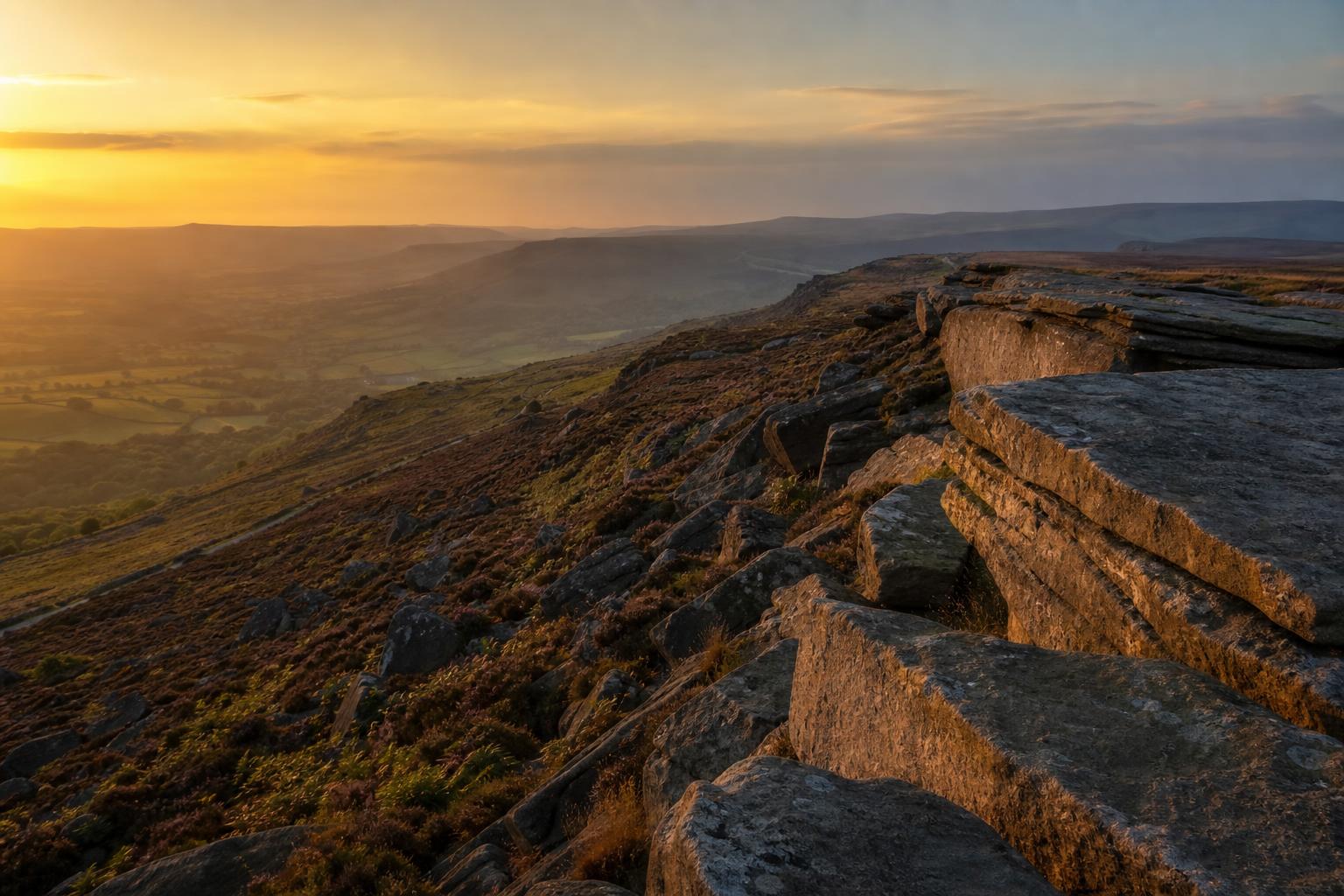 Gritstone edge above the Peak District moorland at golden hour